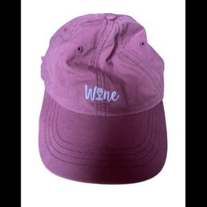 Dark pink baseball style hat that says “wine”
